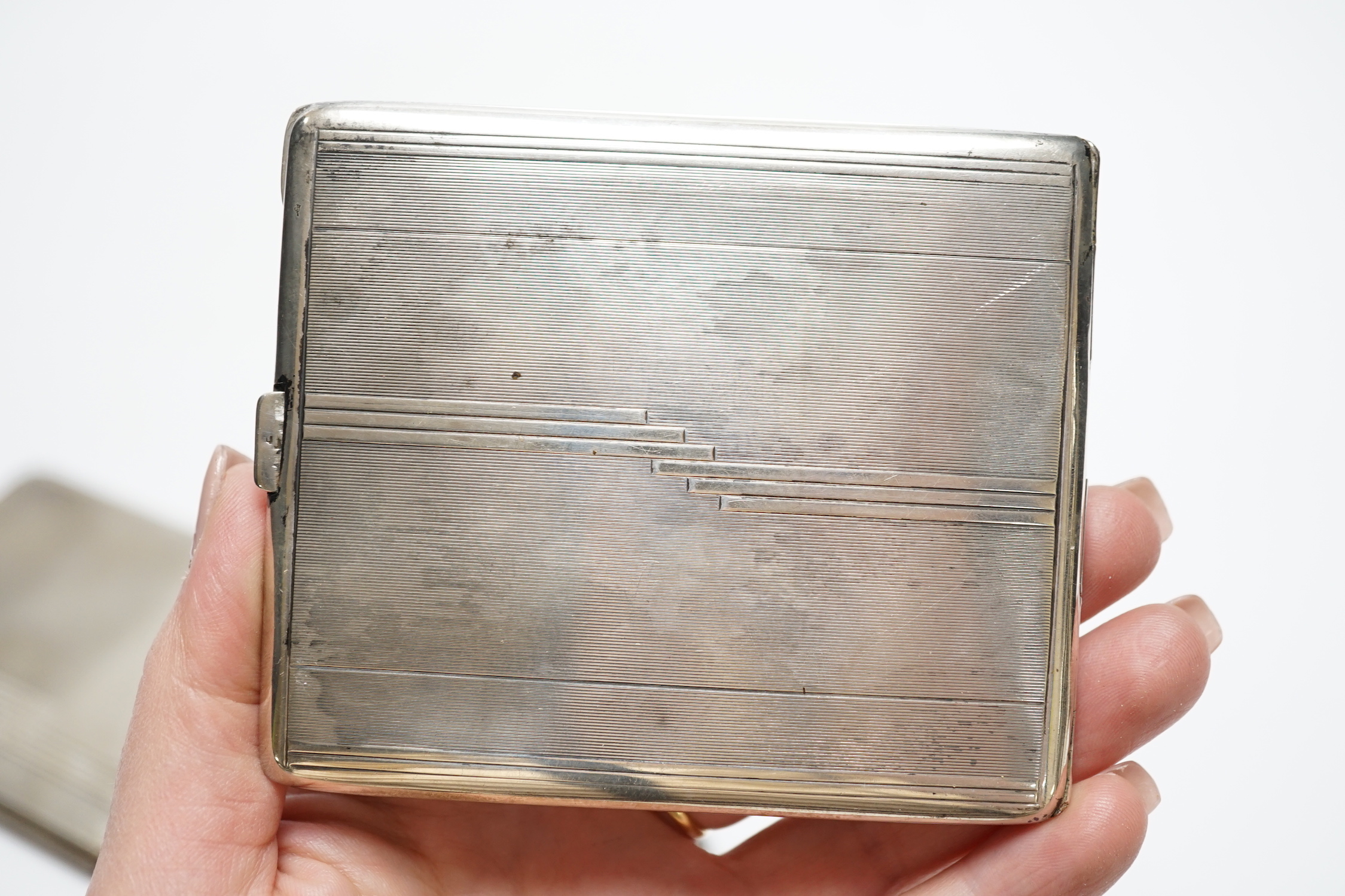 Three silver cigarette cases, including two Art Deco, largest 11.4cm.